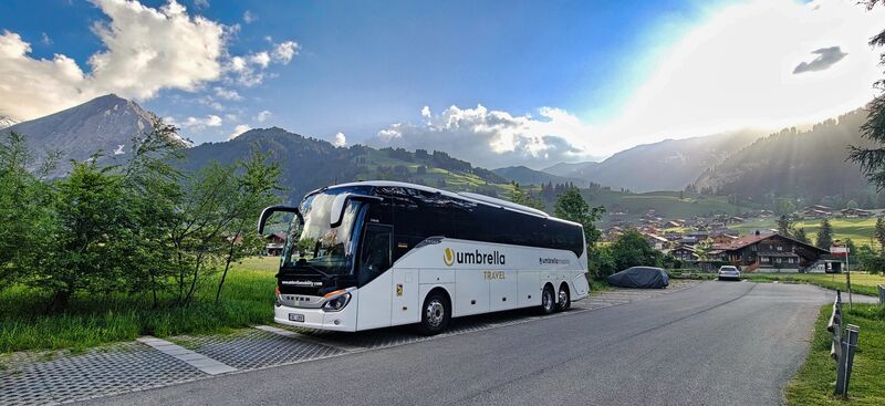 Bílý autobus Setra Umbrella Travel v alpské vesnici