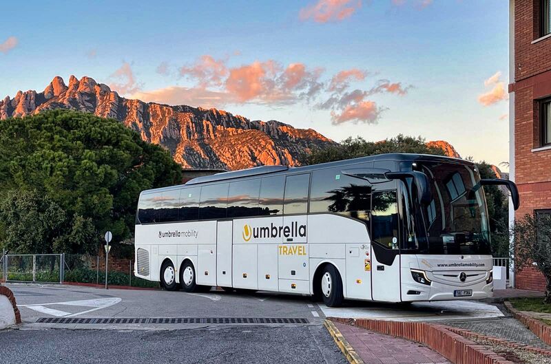 Bílý autobus Mercedes-Benz Umbrella Travel pod horou Montserrat